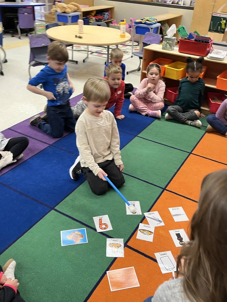 Students in a preschool class do an activity around the letter N with their teacher.