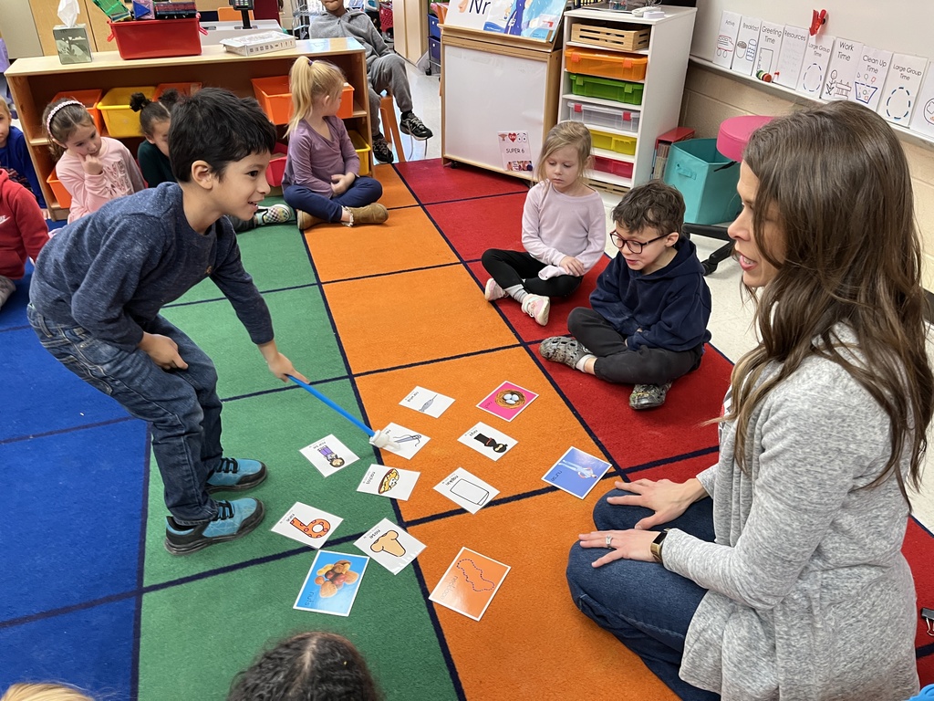 Students in a preschool class do an activity around the letter N with their teacher.