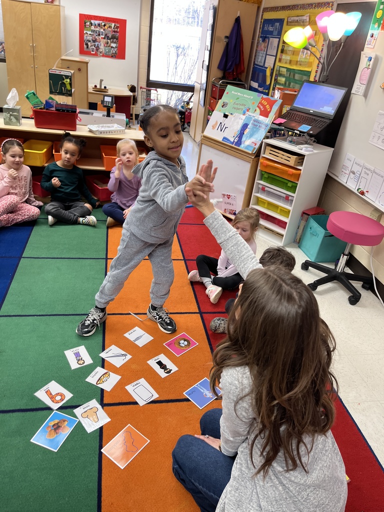 Students in a preschool class do an activity around the letter N with their teacher.