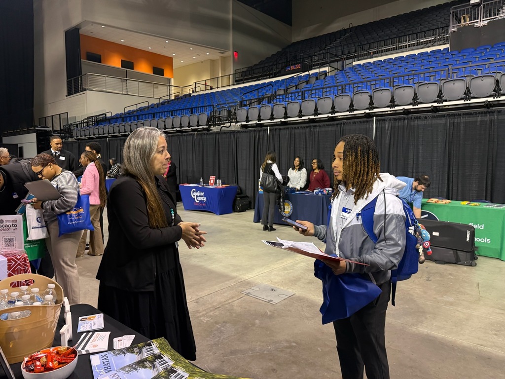 A woman talks to a college student at a job fair.