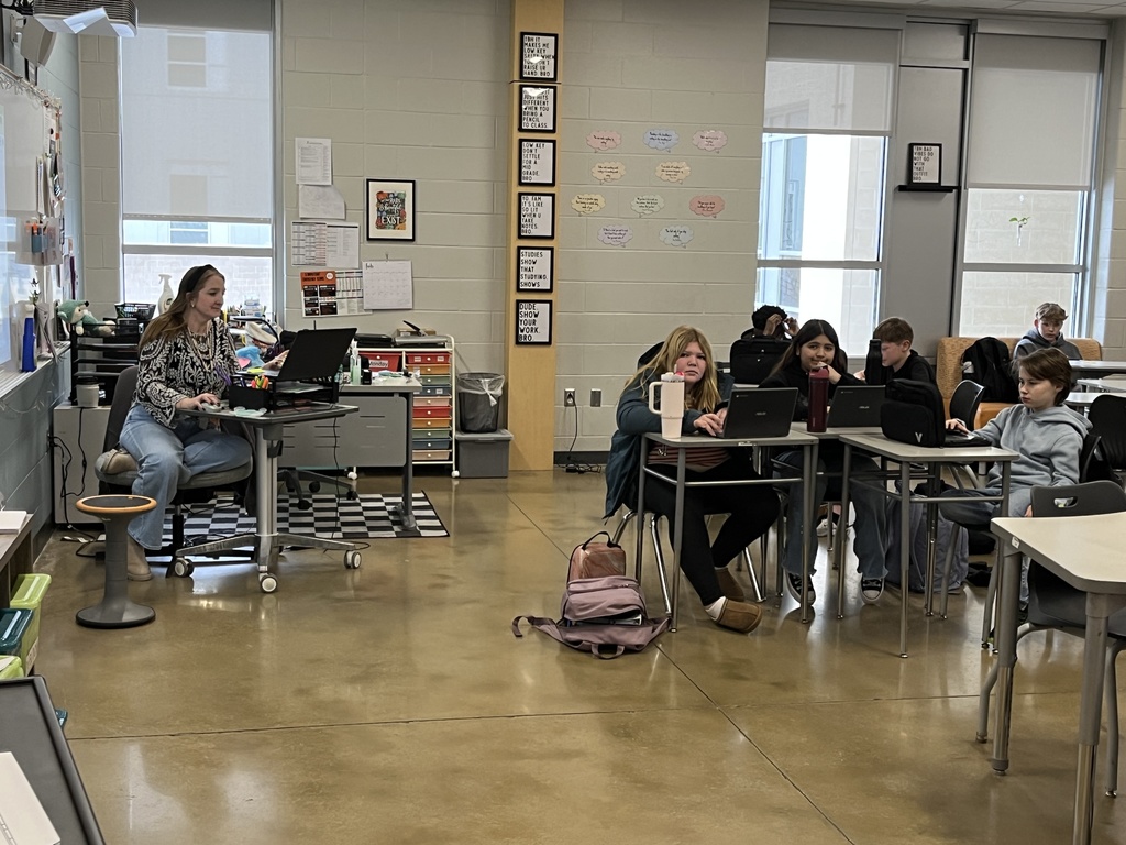 A teacher speaks to a classroom of students. 