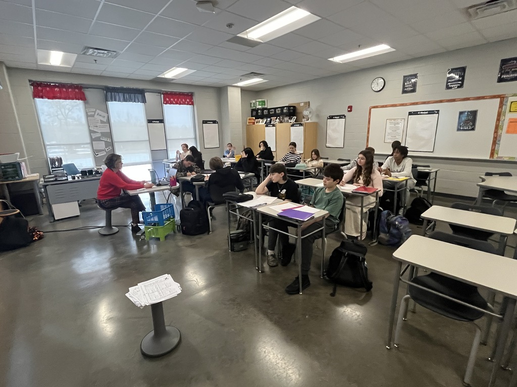 A teacher speaks to a classroom of students. 