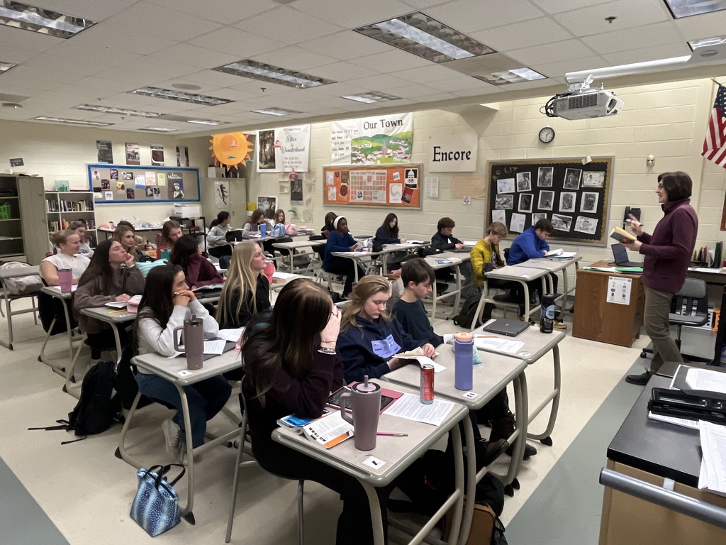 A teacher speaks to a classroom of students. 