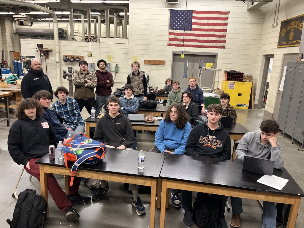 A teacher poses for a photo with his class. 