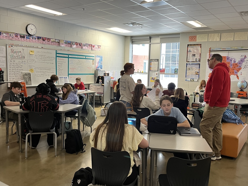 A teacher speaks to a classroom of students. 