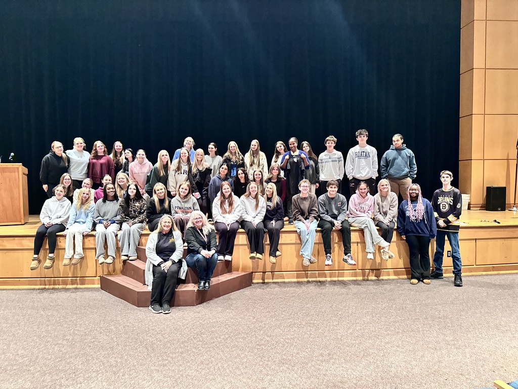 A large group of students and a few adults pose for a photo.
