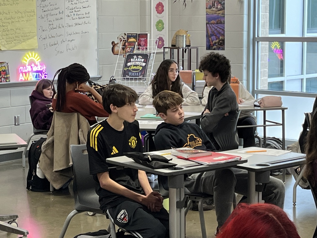 Middle school students look through the book their class is about to study.
