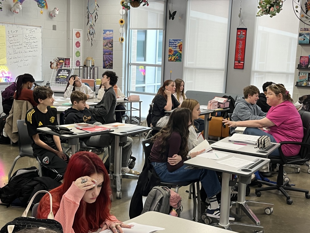 A teacher speaks to middle school students about the book their class is about to study.