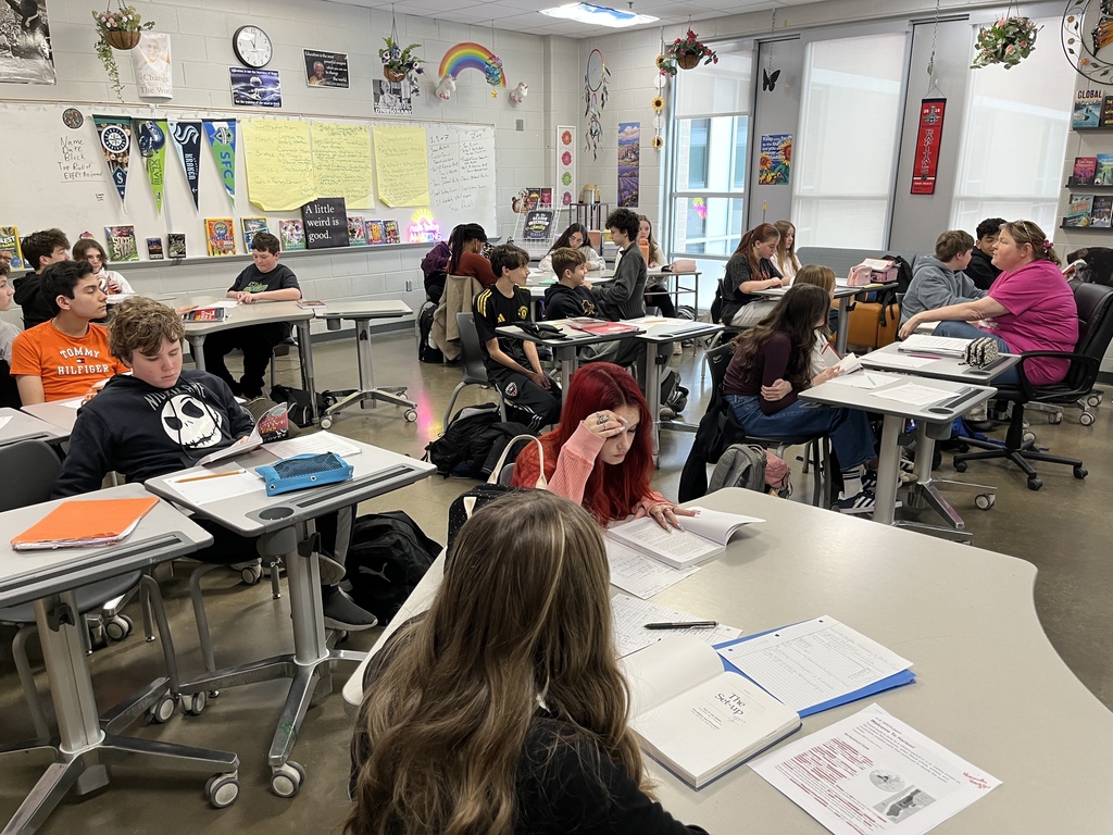 A teacher speaks to middle school students about the book their class is about to study.