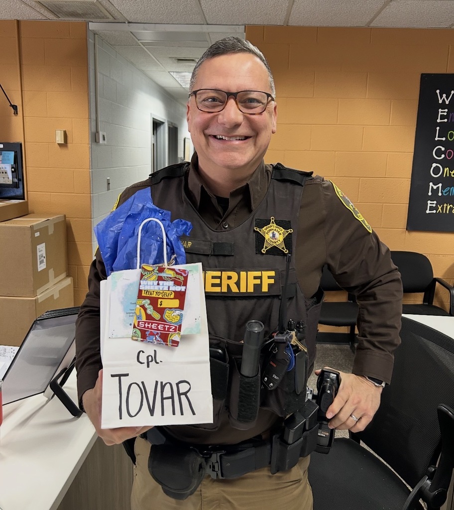 A deputy poses for a photo holding an appreciation bag.