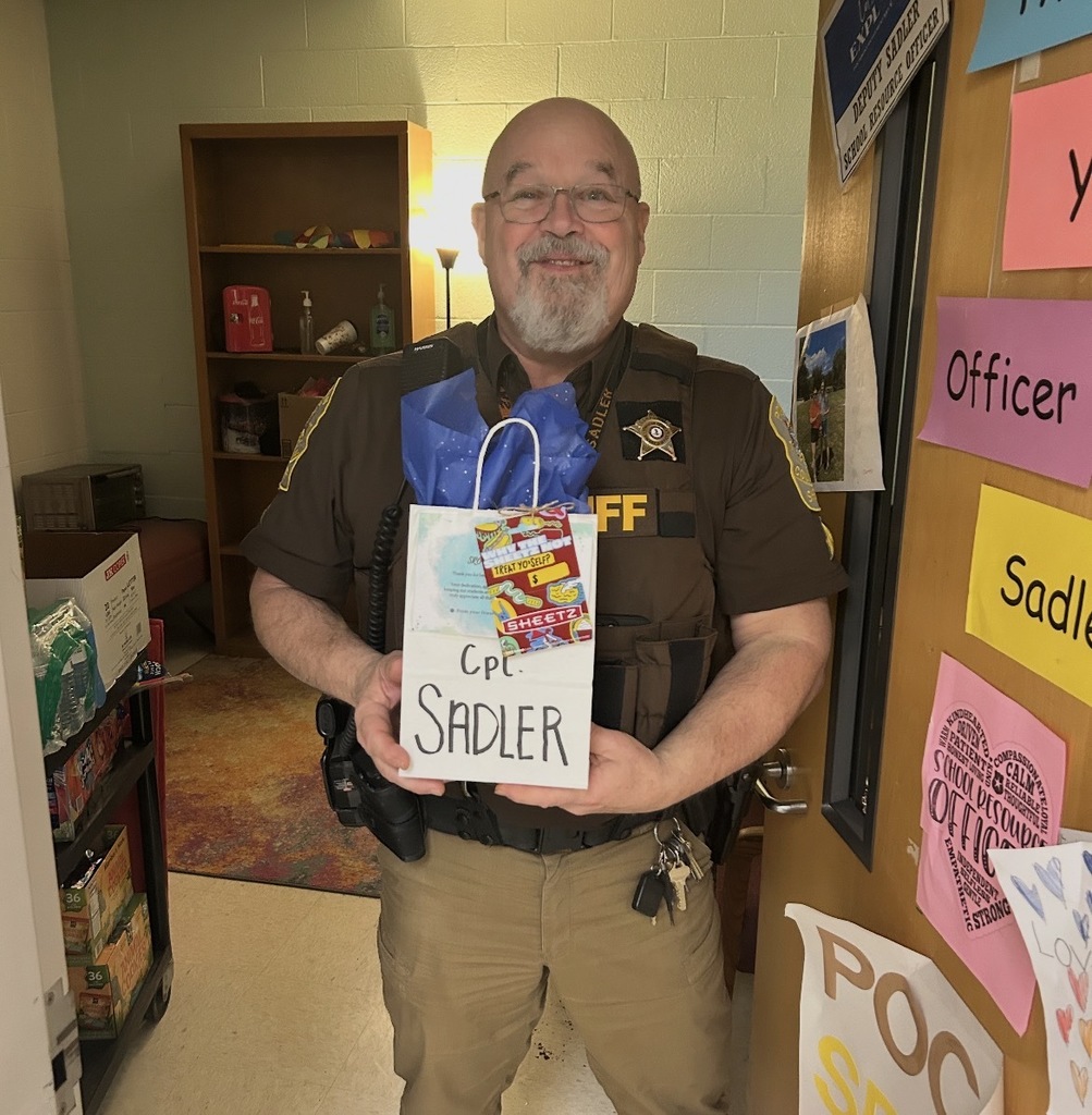 A deputy poses for a photo holding an appreciation bag.