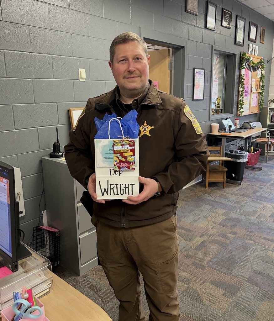 A deputy poses for a photo holding an appreciation bag.