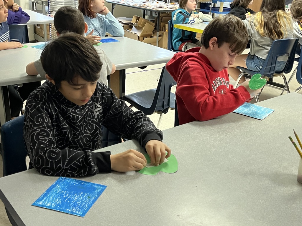 Elementary students in art class bring together the final pieces of their contribution to a koi pond art installation.
