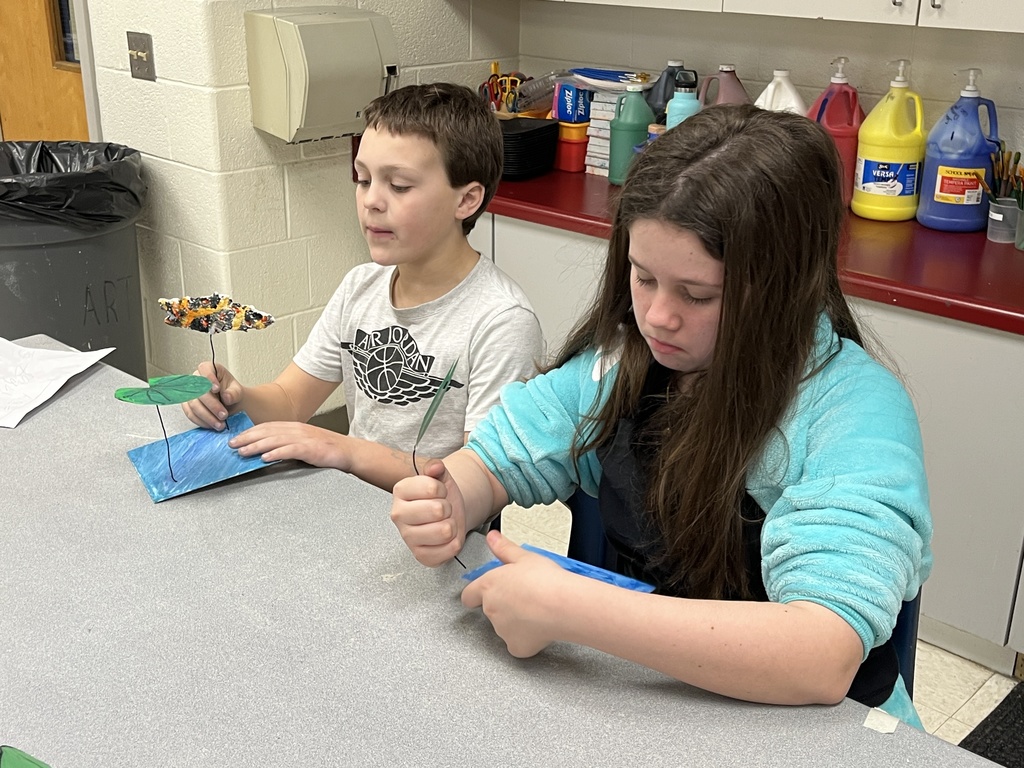 Elementary students in art class bring together the final pieces of their contribution to a koi pond art installation.