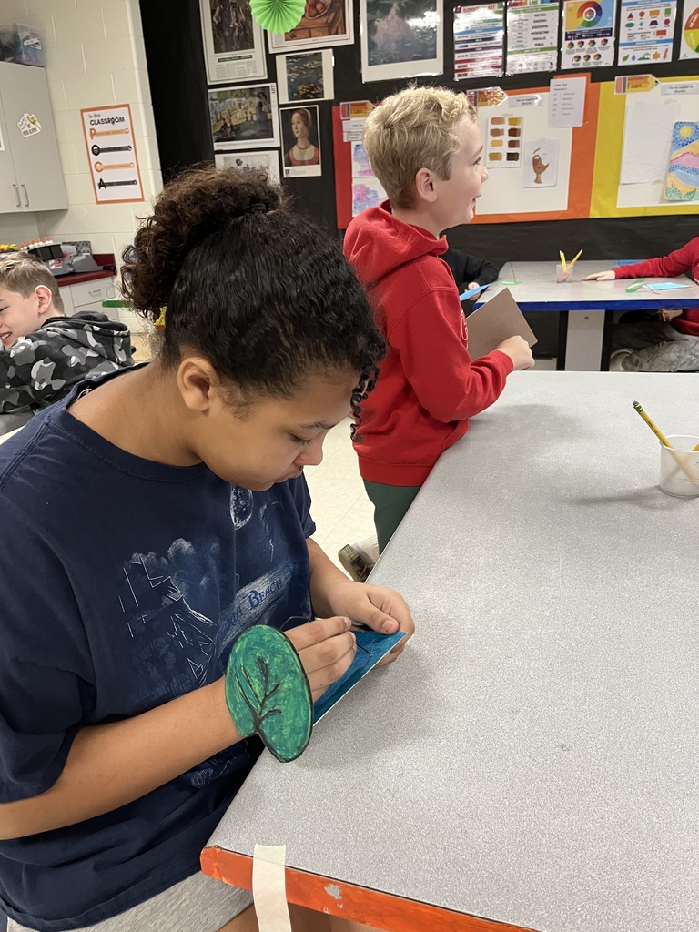 Elementary students in art class bring together the final pieces of their contribution to a koi pond art installation.