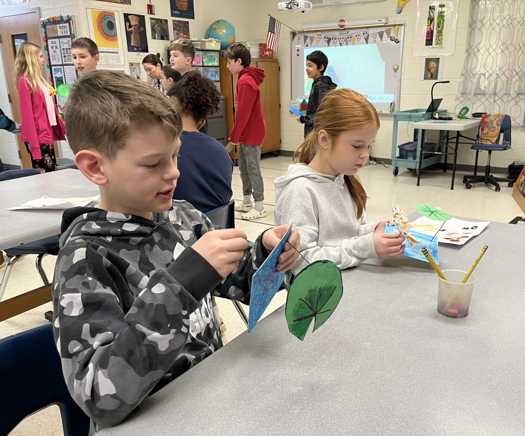Elementary students in art class bring together the final pieces of their contribution to a koi pond art installation.