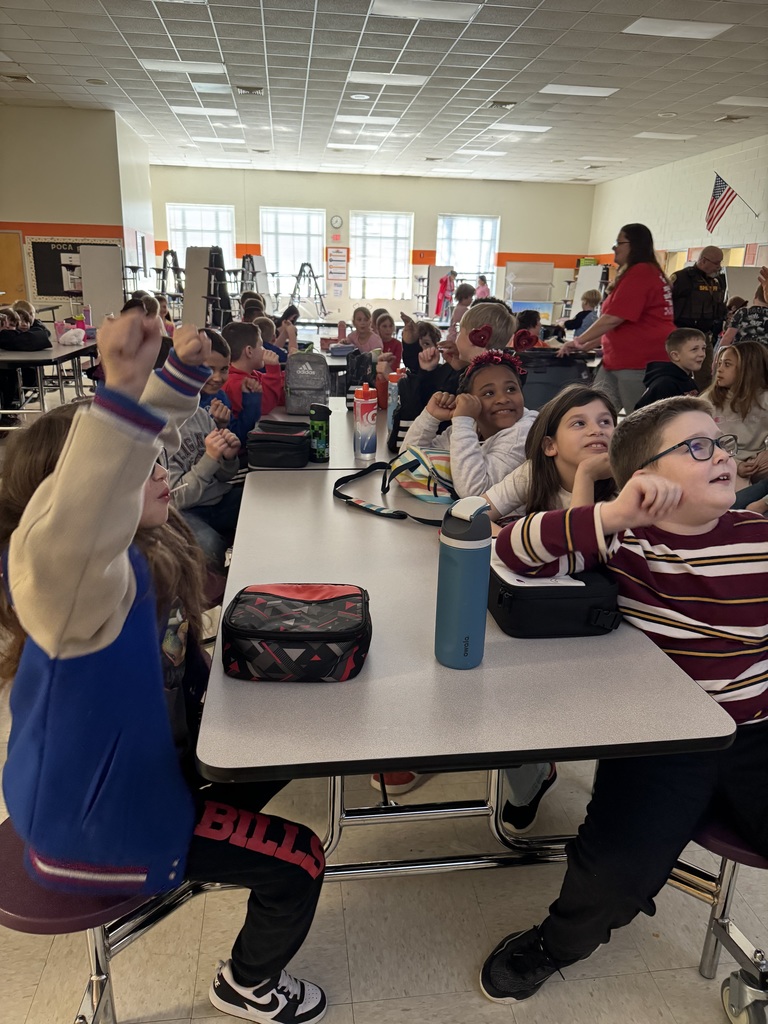 Elementary students watch the Olympics at lunch and cheer.