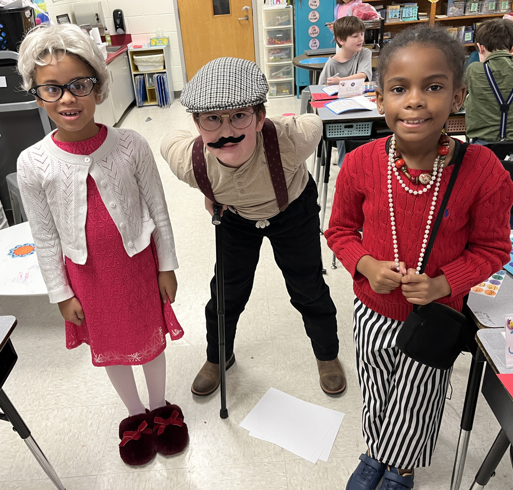 Children dressed up for the 100th day of school pose for a photo.
