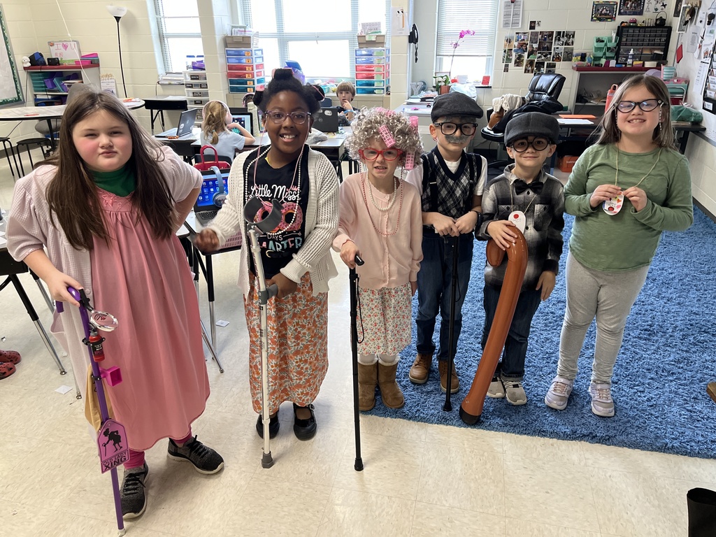 Children dressed up for the 100th day of school pose for a photo.