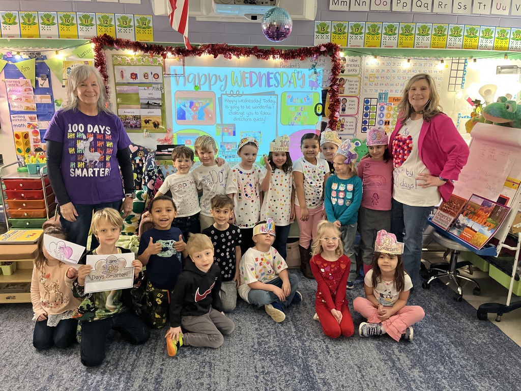 Children and two adults dressed up for the 100th day of school pose for a photo.