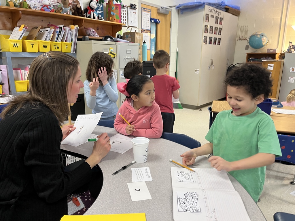 A teacher works with children at a literacy station. 