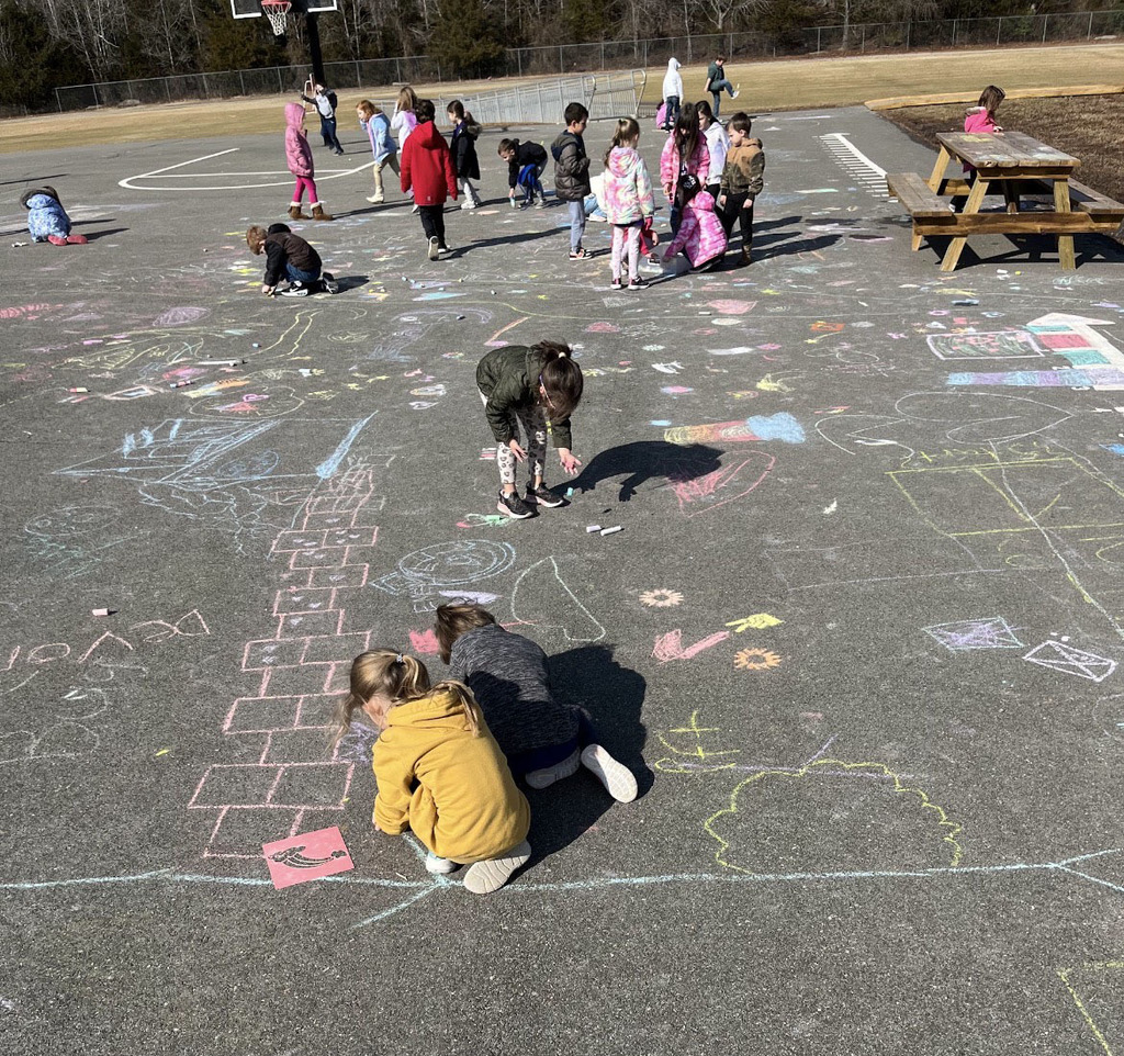 Students create chalk art drawn for Kindness Week.
