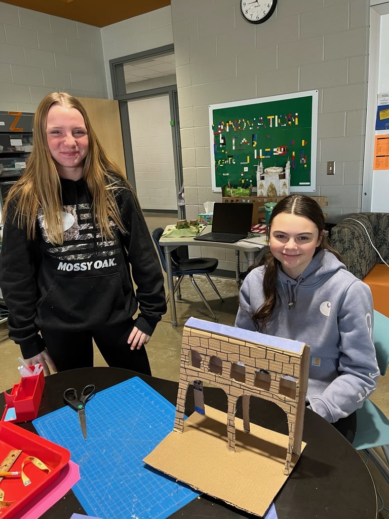 Students pose with a model of an ancient monument built on a 1:200 scale.