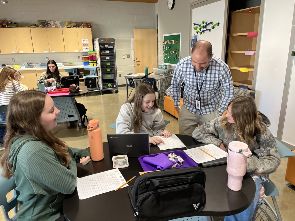 Students work on a model of an ancient monument built on a 1:200 scale. A teacher helps.