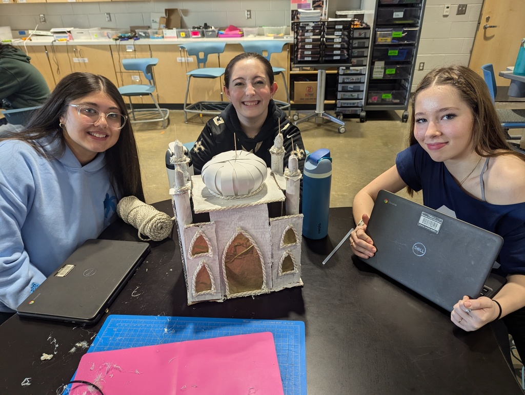 Students pose with a model of an ancient monument built on a 1:200 scale.