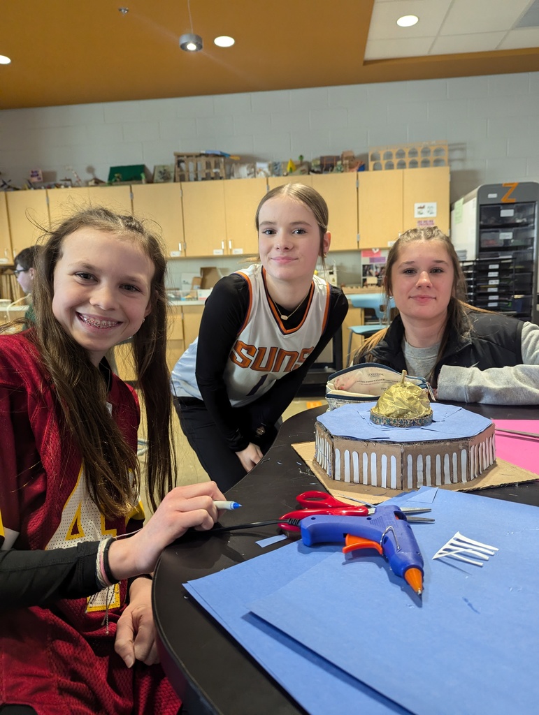 Students pose with a model of an ancient monument built on a 1:200 scale.