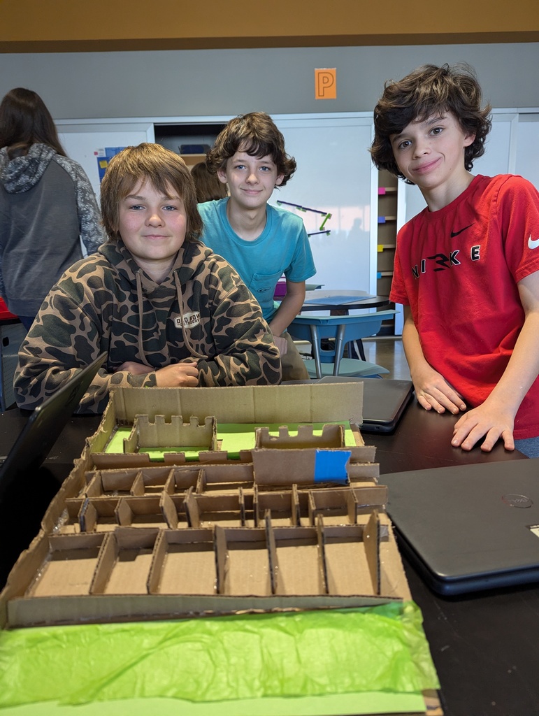 Students pose with a model of an ancient monument built on a 1:200 scale.