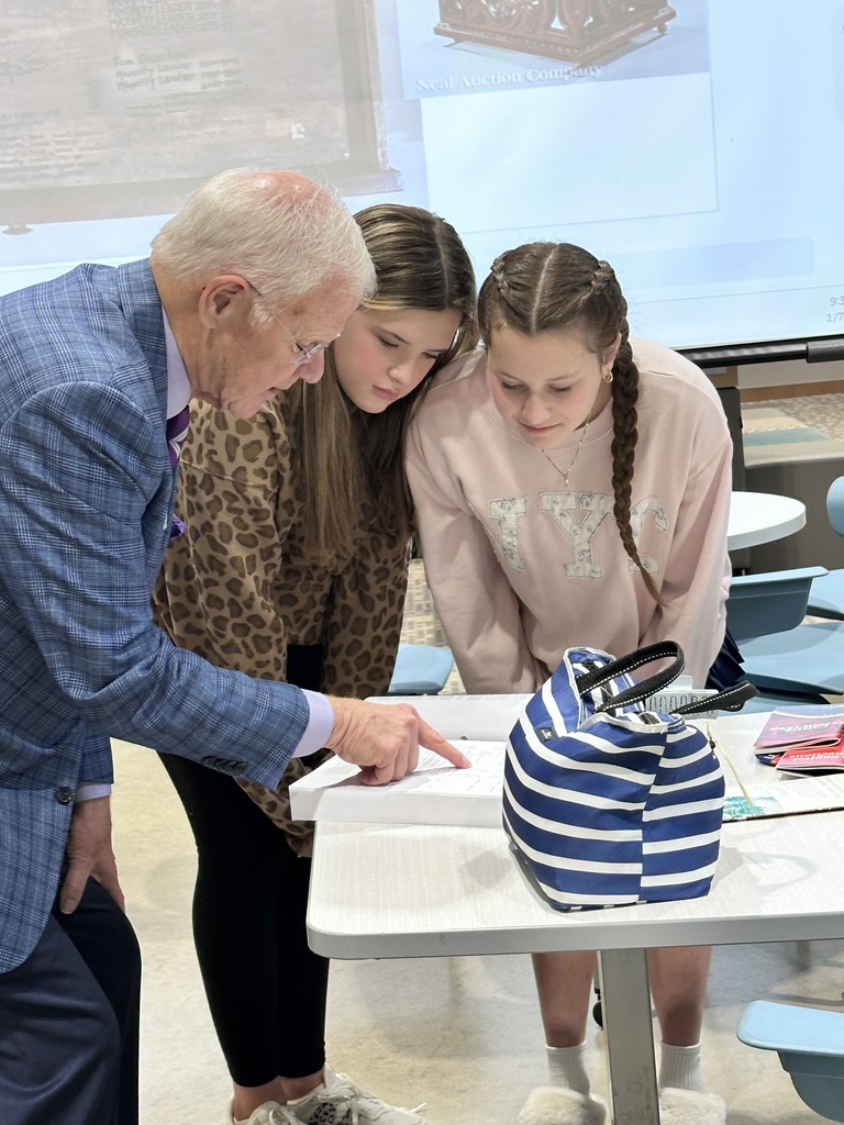 A politician speaks to two students.