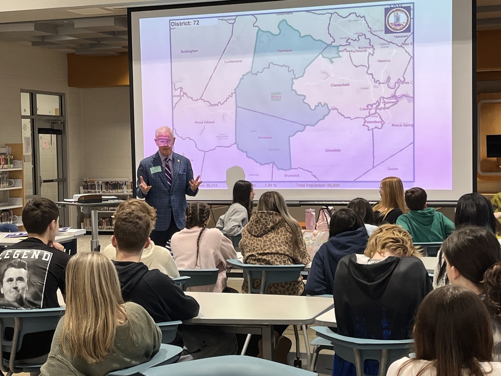 A politician speaks to a group of students in a middle school library.