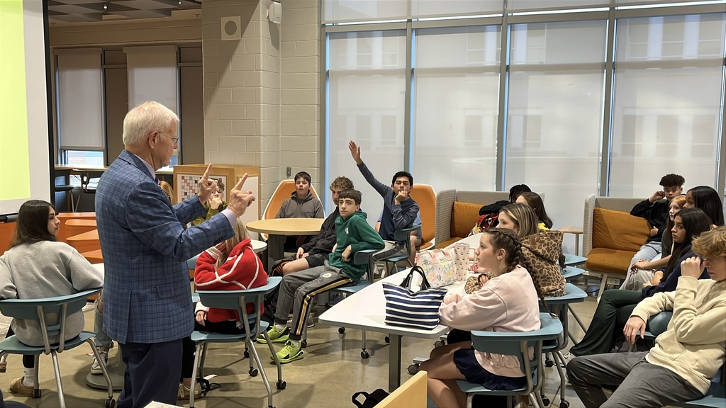 A politician speaks to a group of students in a middle school library.
