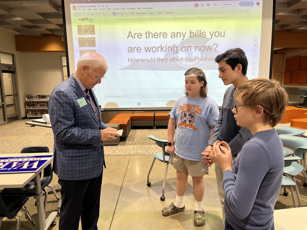 A politician speaks to three students.