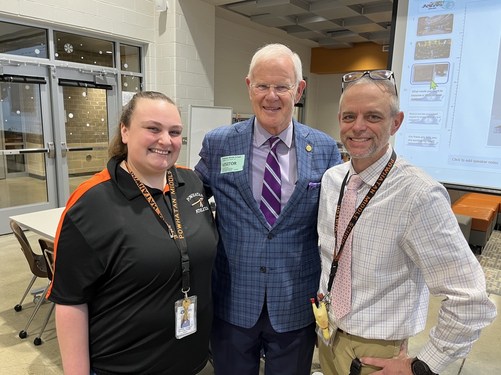 Three adults pose for a photo.