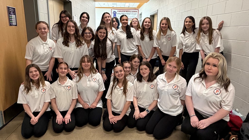 A group of teen girls in a middle school chorus pose for a photo together