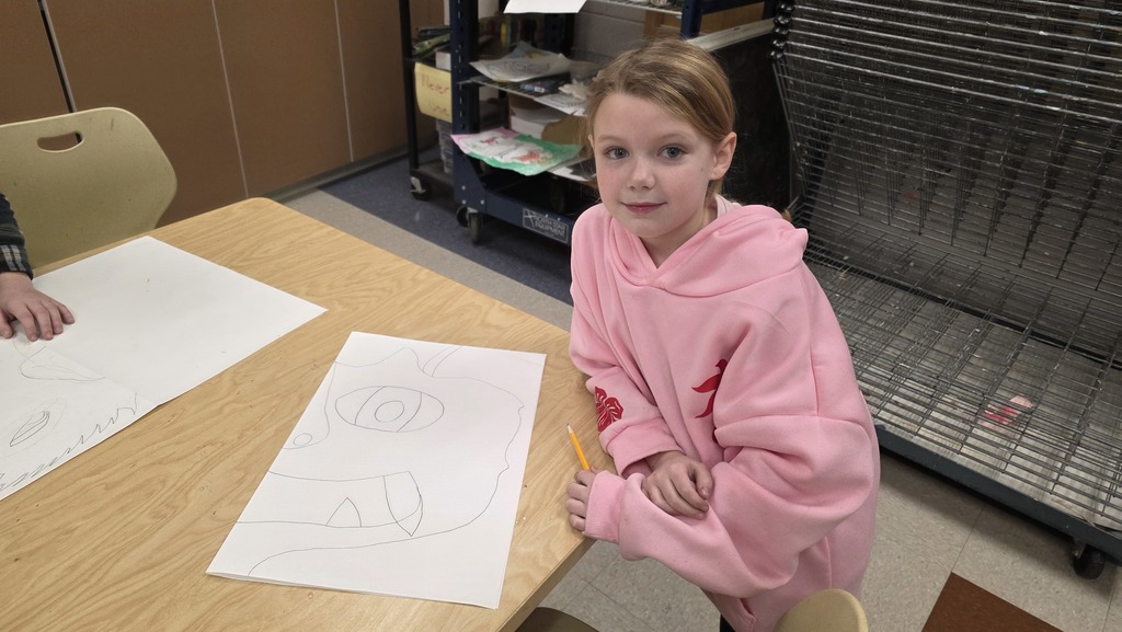 A student in art class draws a ceremonial mask inspired by an African tribe.