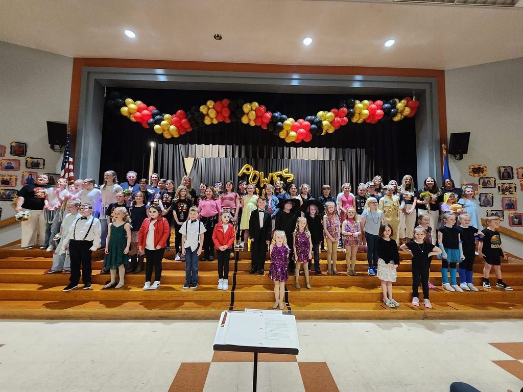 A large group of student performers pose for photo at a talent show.