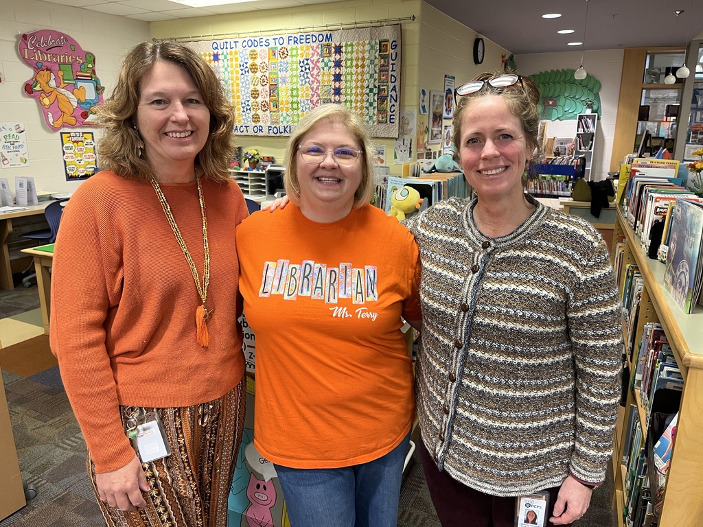 Three women pose for a photo. 
