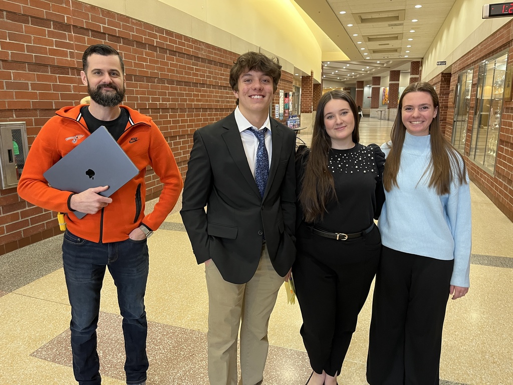 A principal and three students shadowing admin pose for a photo.