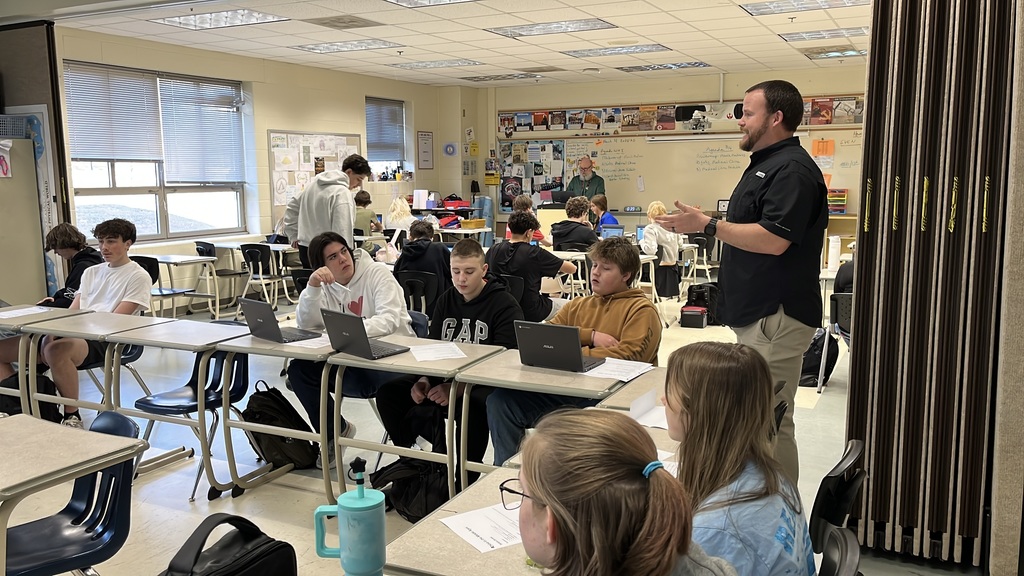 A teacher introduces a March Madness-themed history project to students.