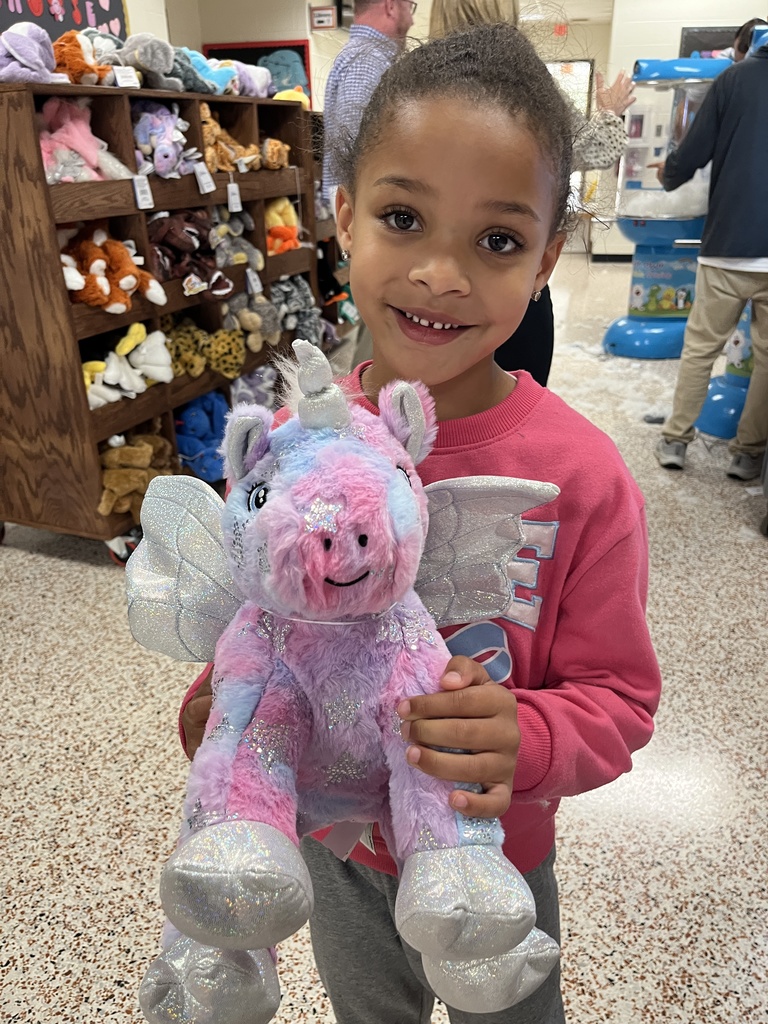 A child poses with a new stuffed animal.