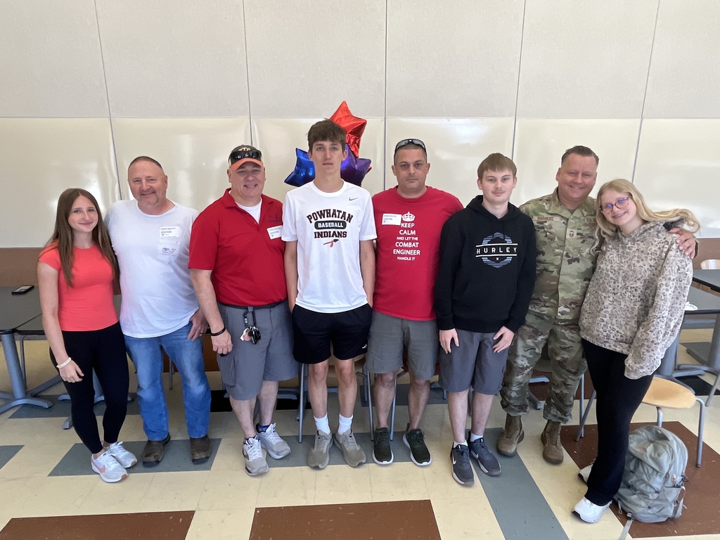 A group of men and teens pose for a group photo.