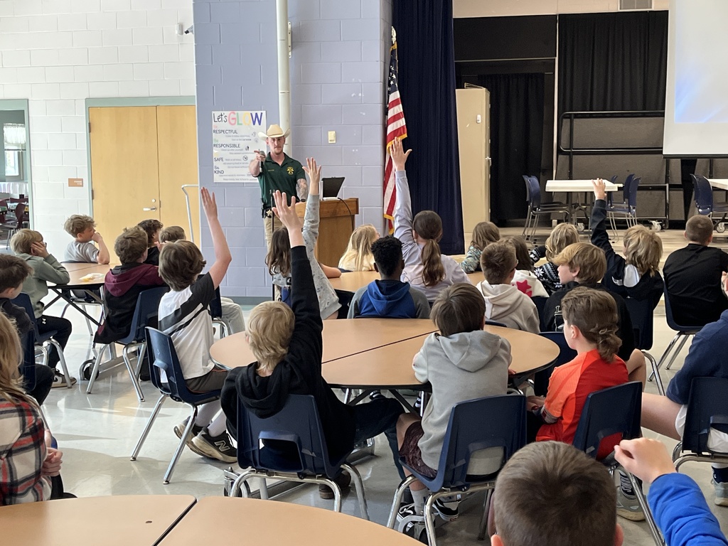 A detective speaks to a group of students about cybersecurity in a school assdembly. 