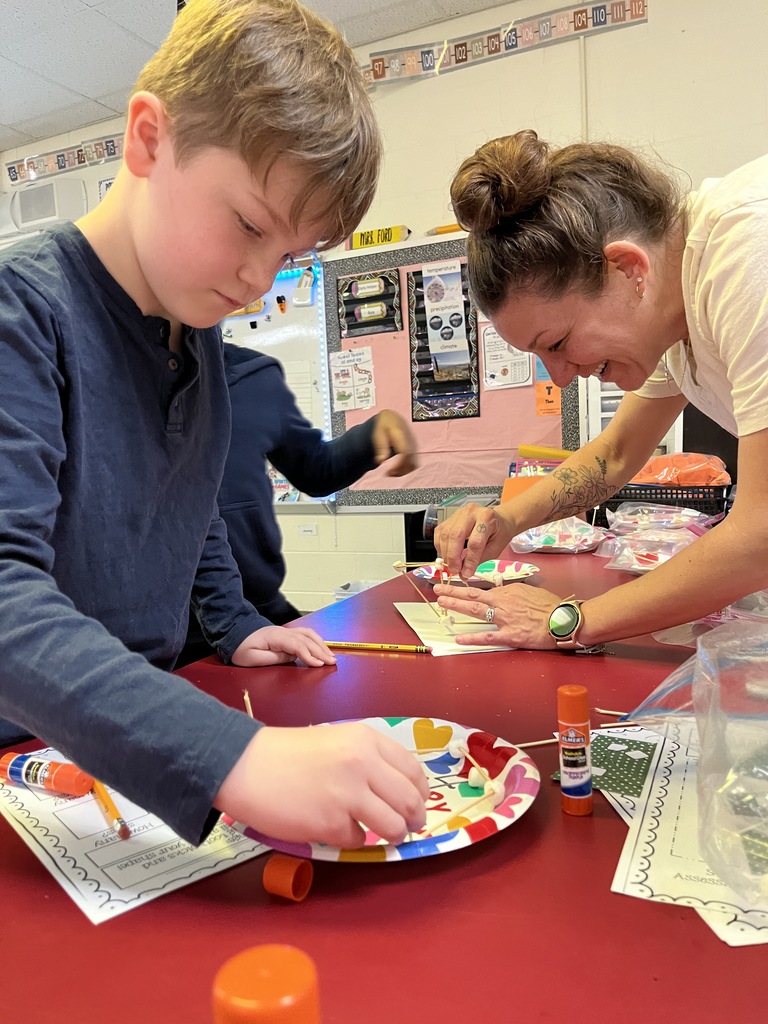 A student and a teacher use marshmallows and toothpicks to build geometric shapes.