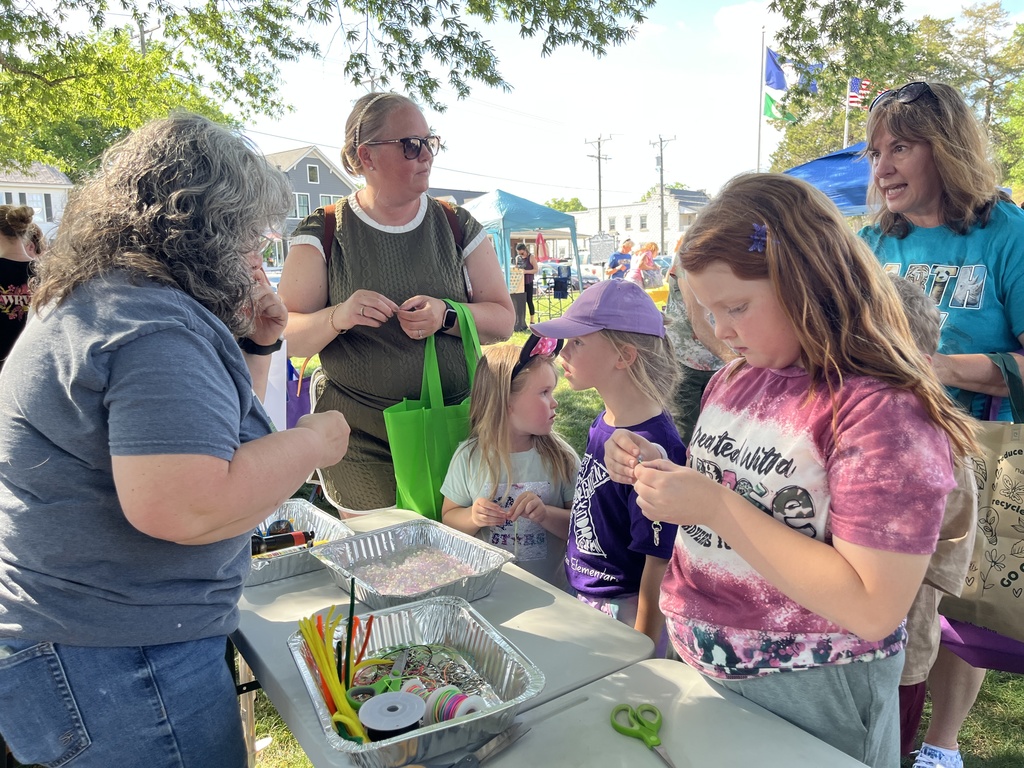 A family visits a booth at an Eartyh Day Festival. 