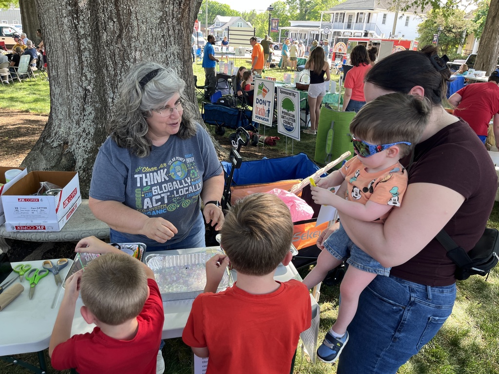 A family visits a booth at an Eartyh Day Festival. 