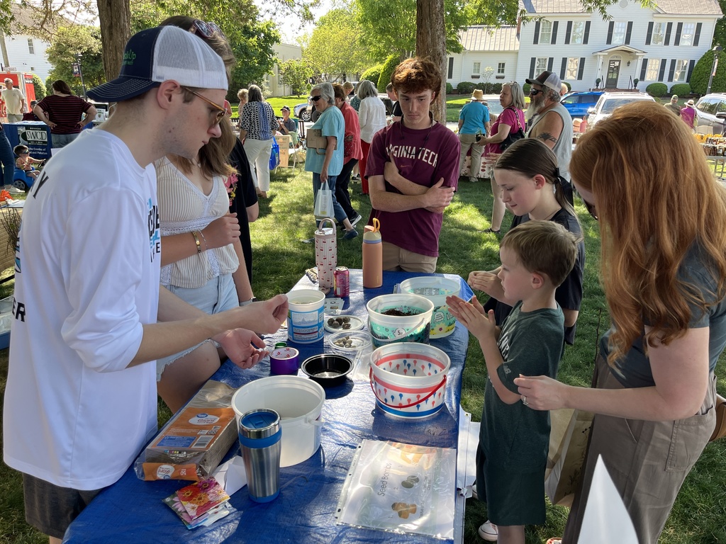 A family visits a booth at an Eartyh Day Festival. 
