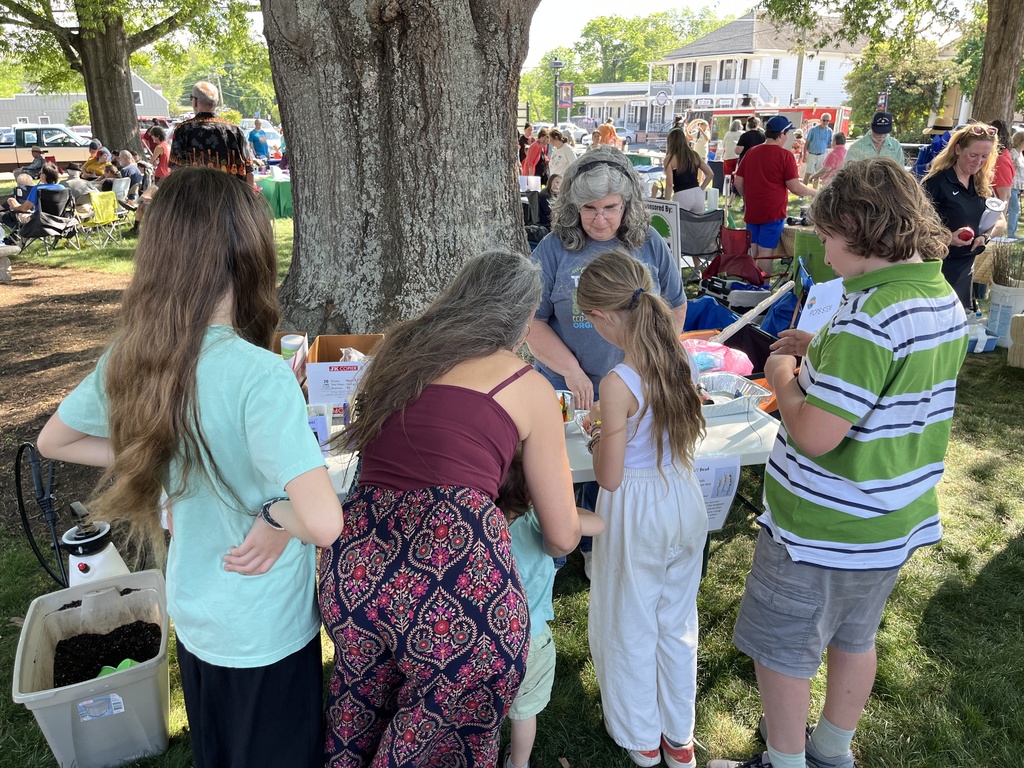 A family visits a booth at an Eartyh Day Festival. 